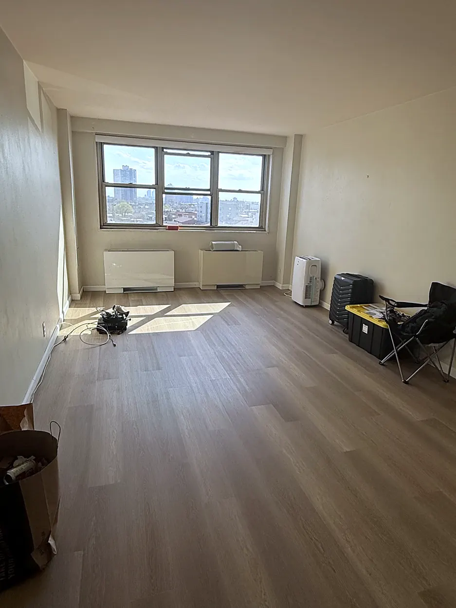 Living room (empty, wide plank floor) after a move-in/move-out cleaning in Guttenberg, NJ