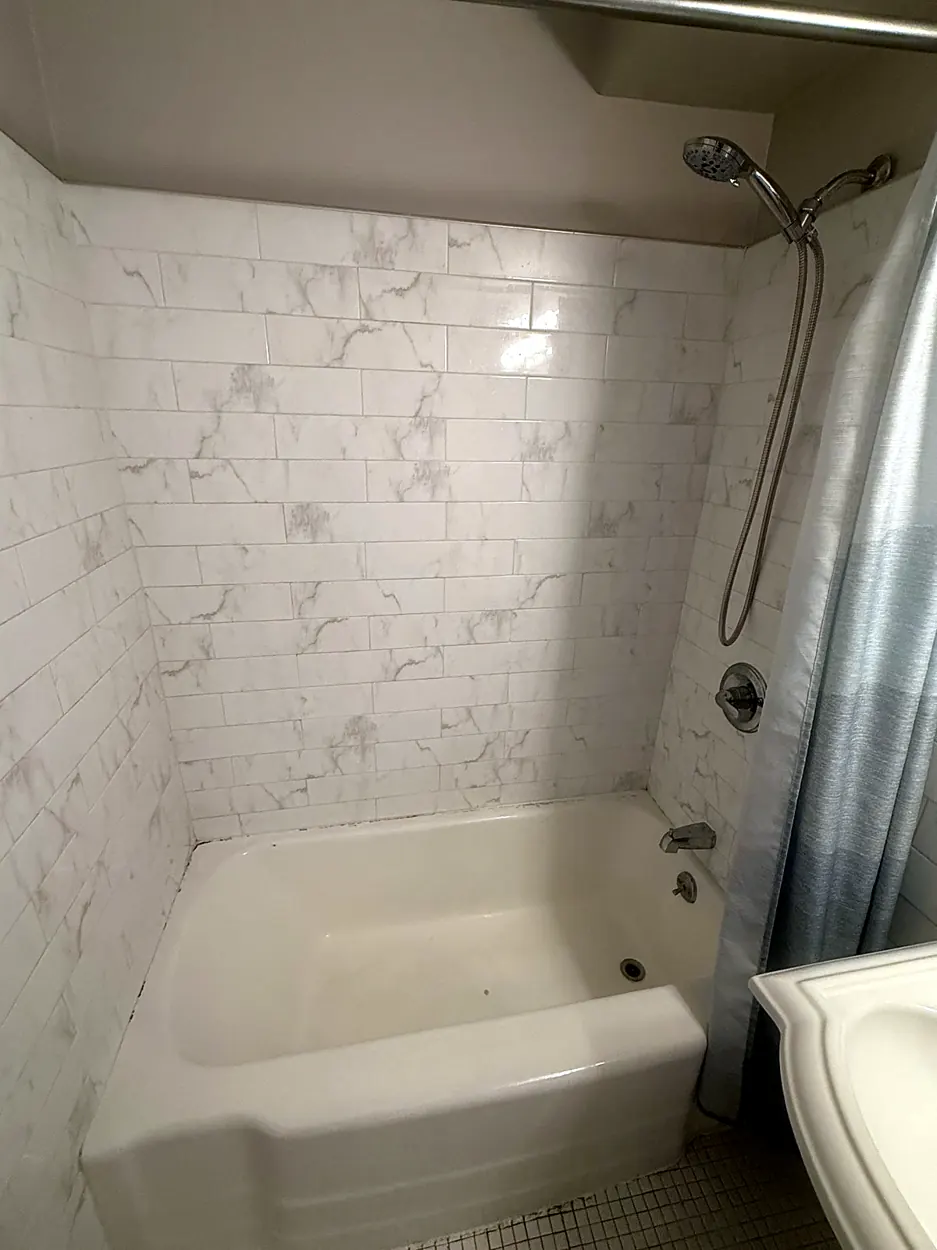 Bathtub (marble-look tile) after a move-in/move-out cleaning in Guttenberg, NJ