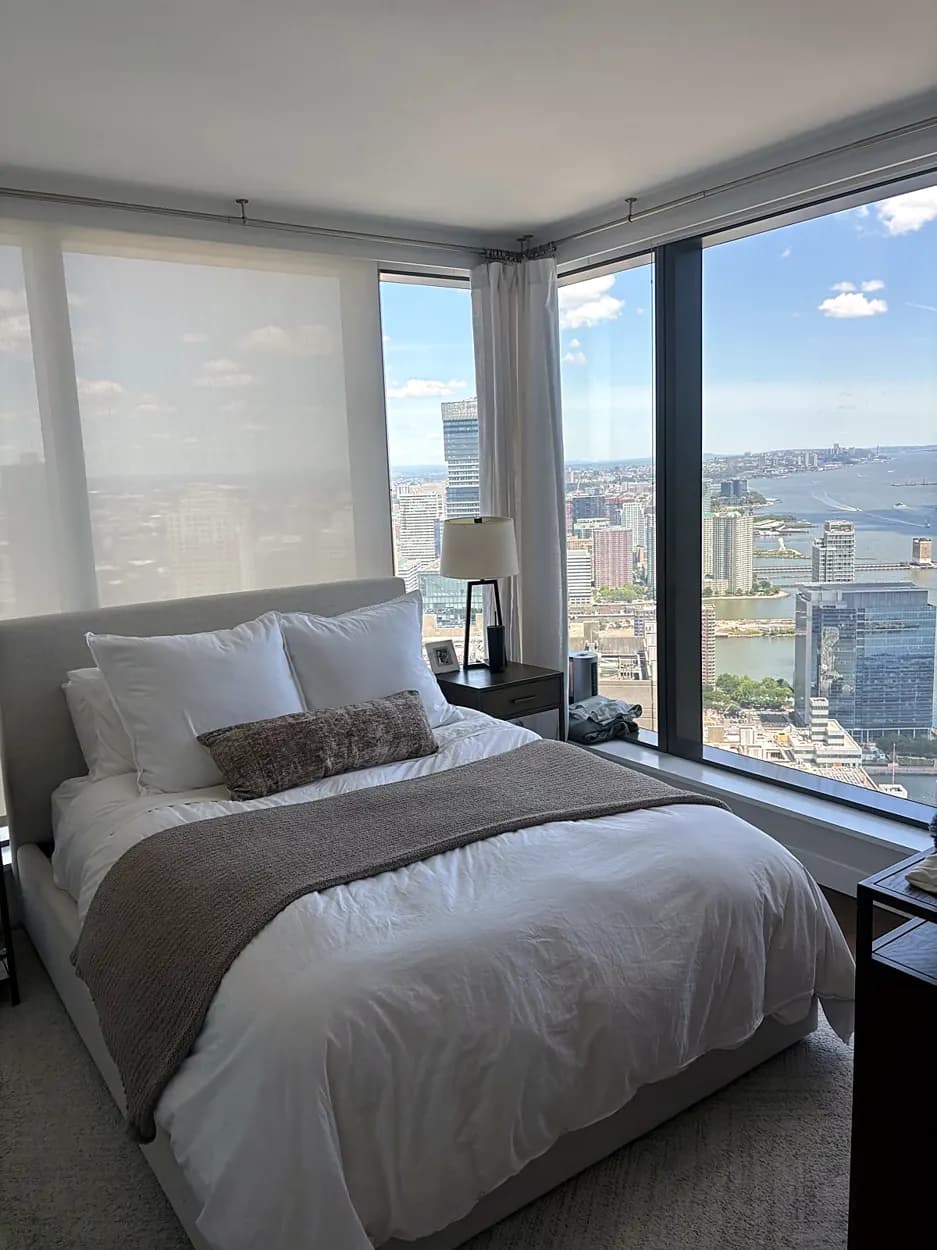 Bedroom (high-rise view, made bed) after a home cleaning in Jersey City, NJ