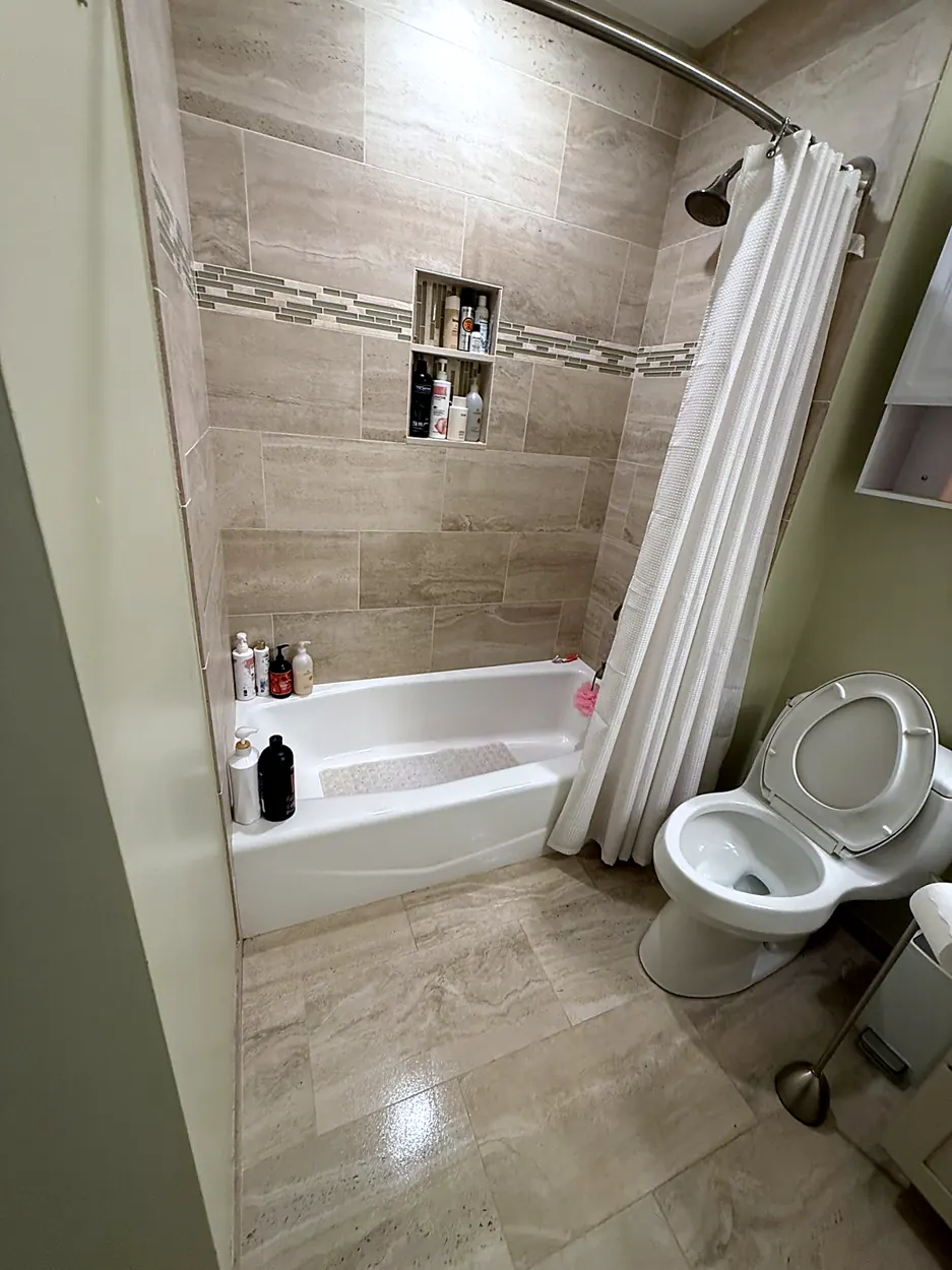 Bathroom (tiled tub surround, glossy floor) after a home cleaning in Montville, NJ