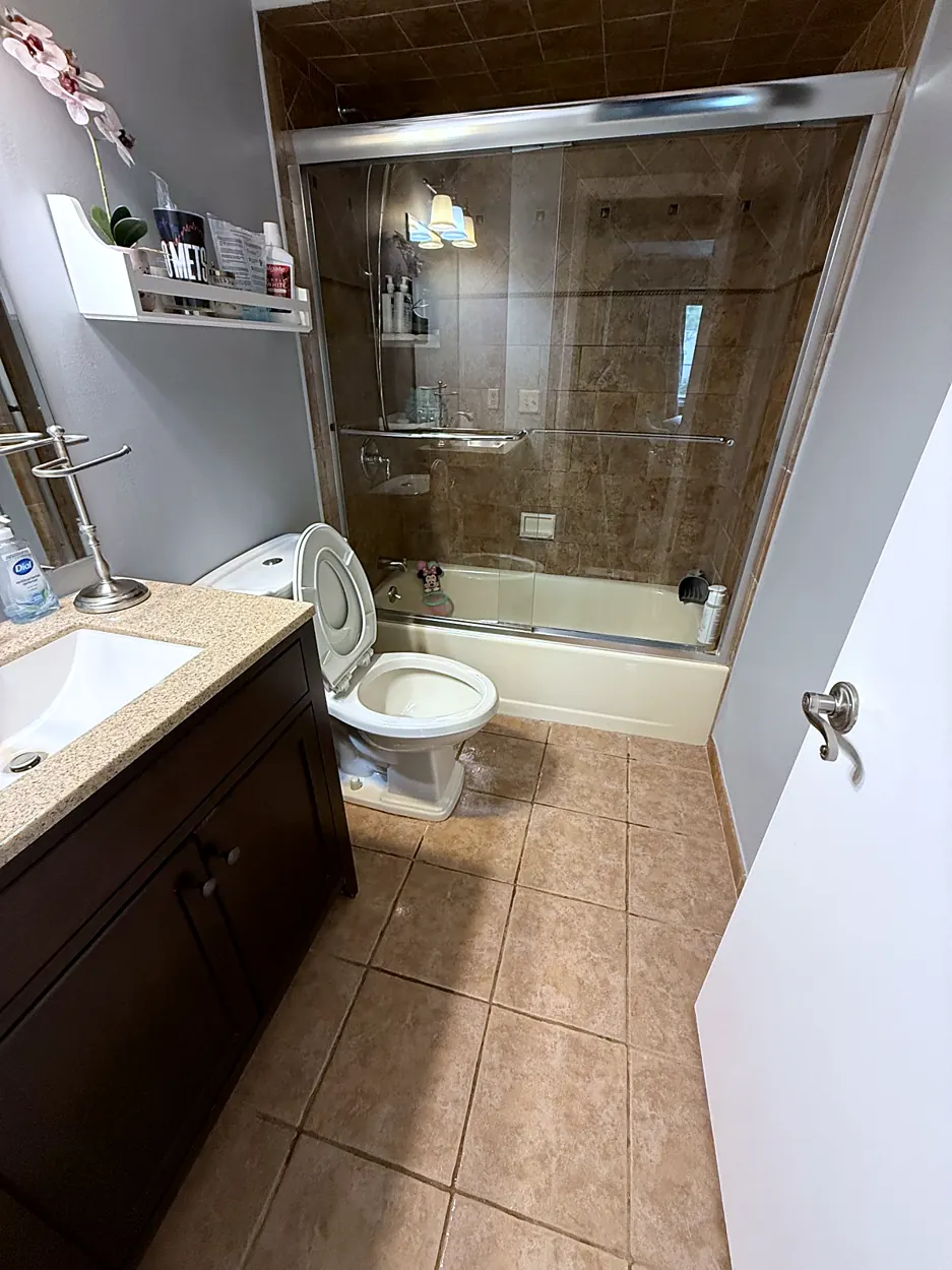 Bathroom (glass tub doors, tile floor) after a home cleaning in Nutley, NJ