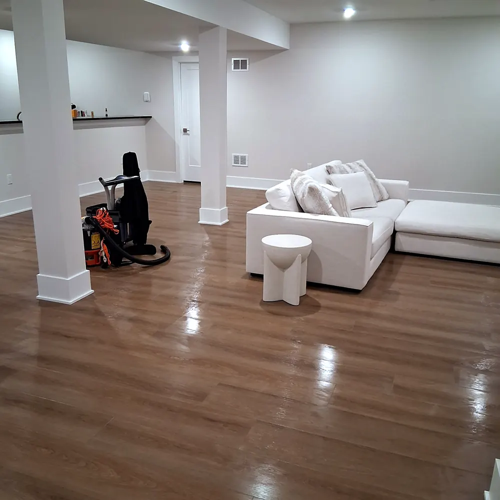 Basement (white sofa, polished floor) after a home cleaning in River Vale, NJ