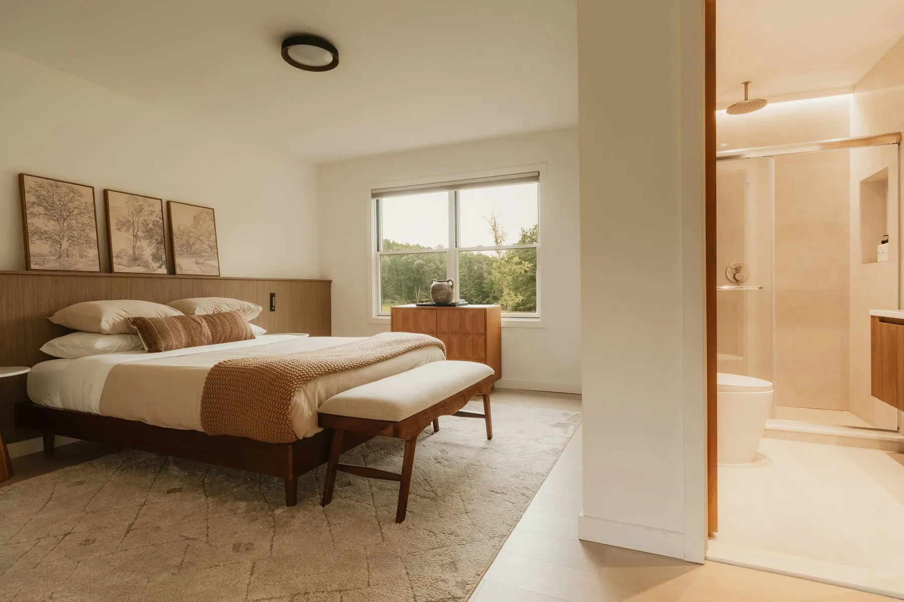 Guest suite with a made bed and en-suite glass shower