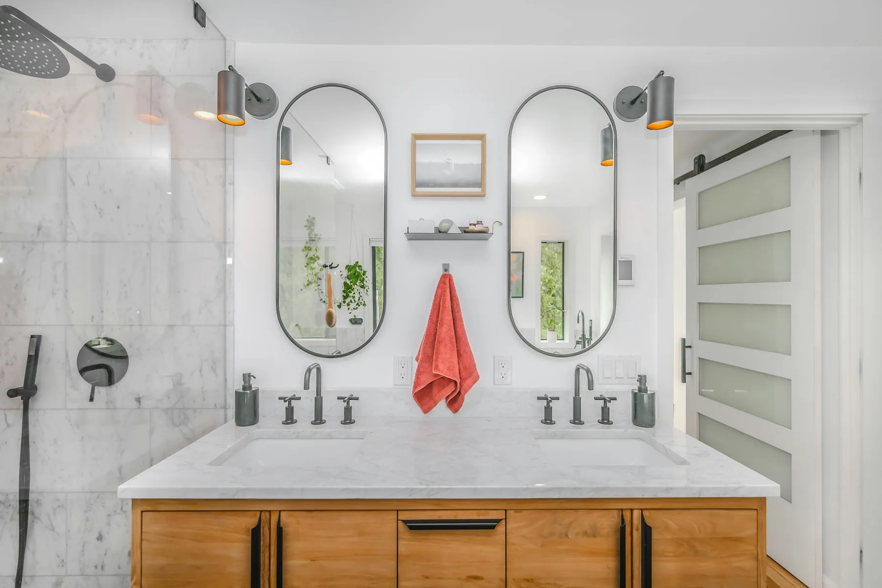 Marble bathroom with a double vanity and pill-shaped mirrors