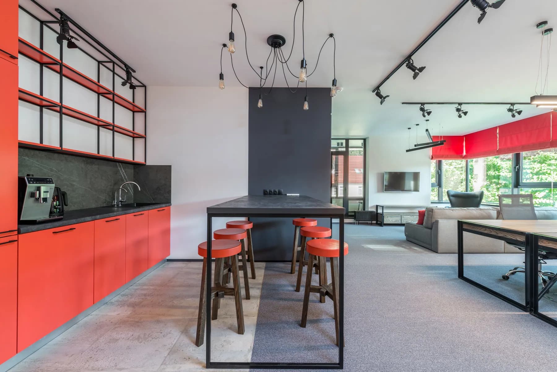 Office kitchen with red cabinets and a high-top table