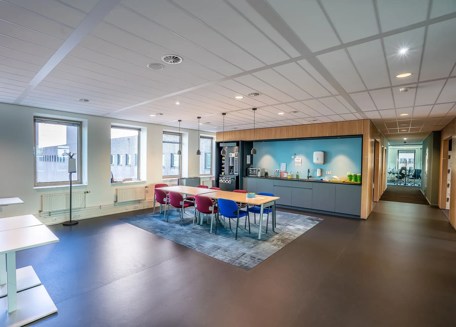 Office kitchen and dining area with colorful chairs
