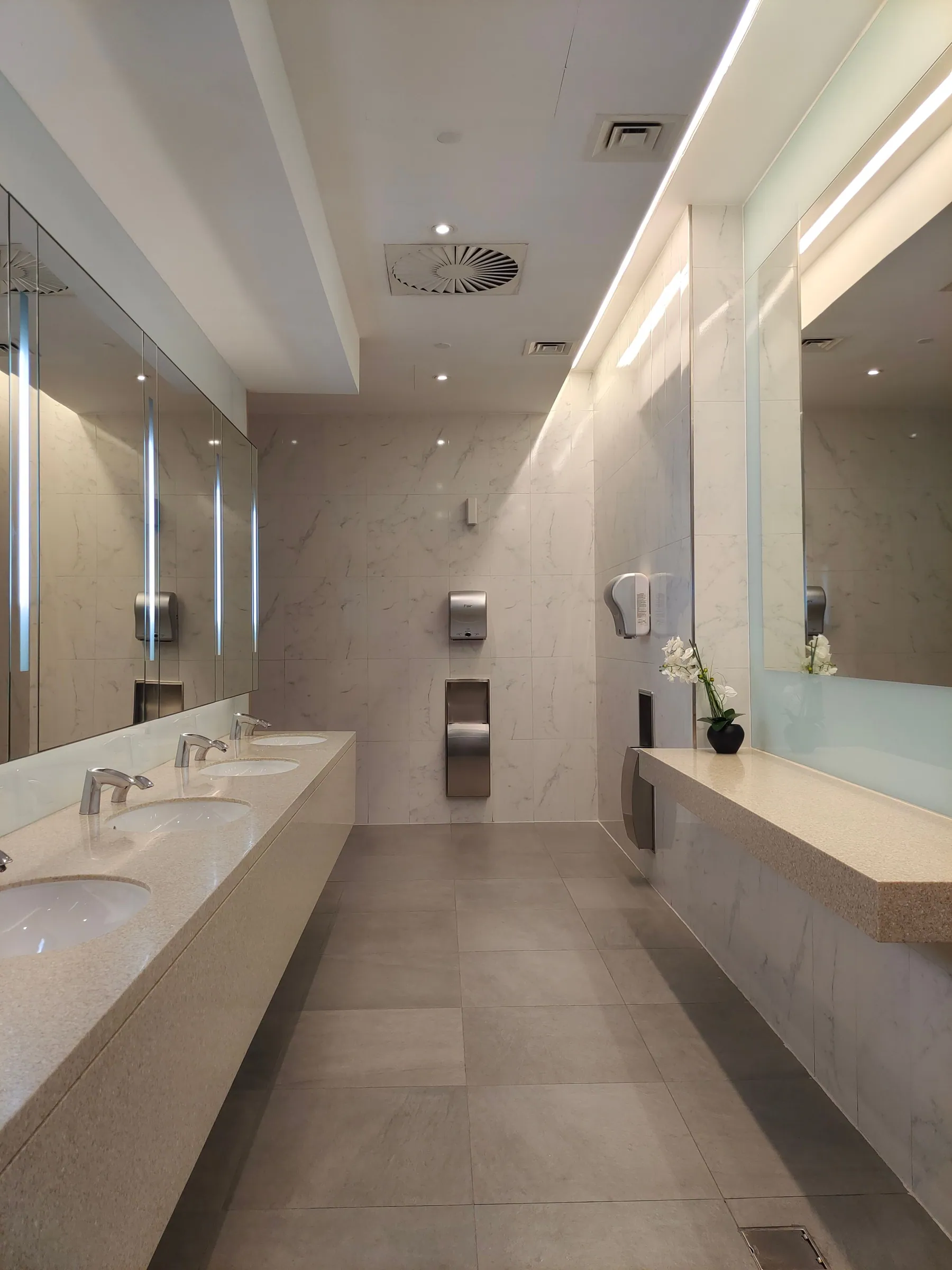 Upscale commercial restroom with marble counters and long mirrors