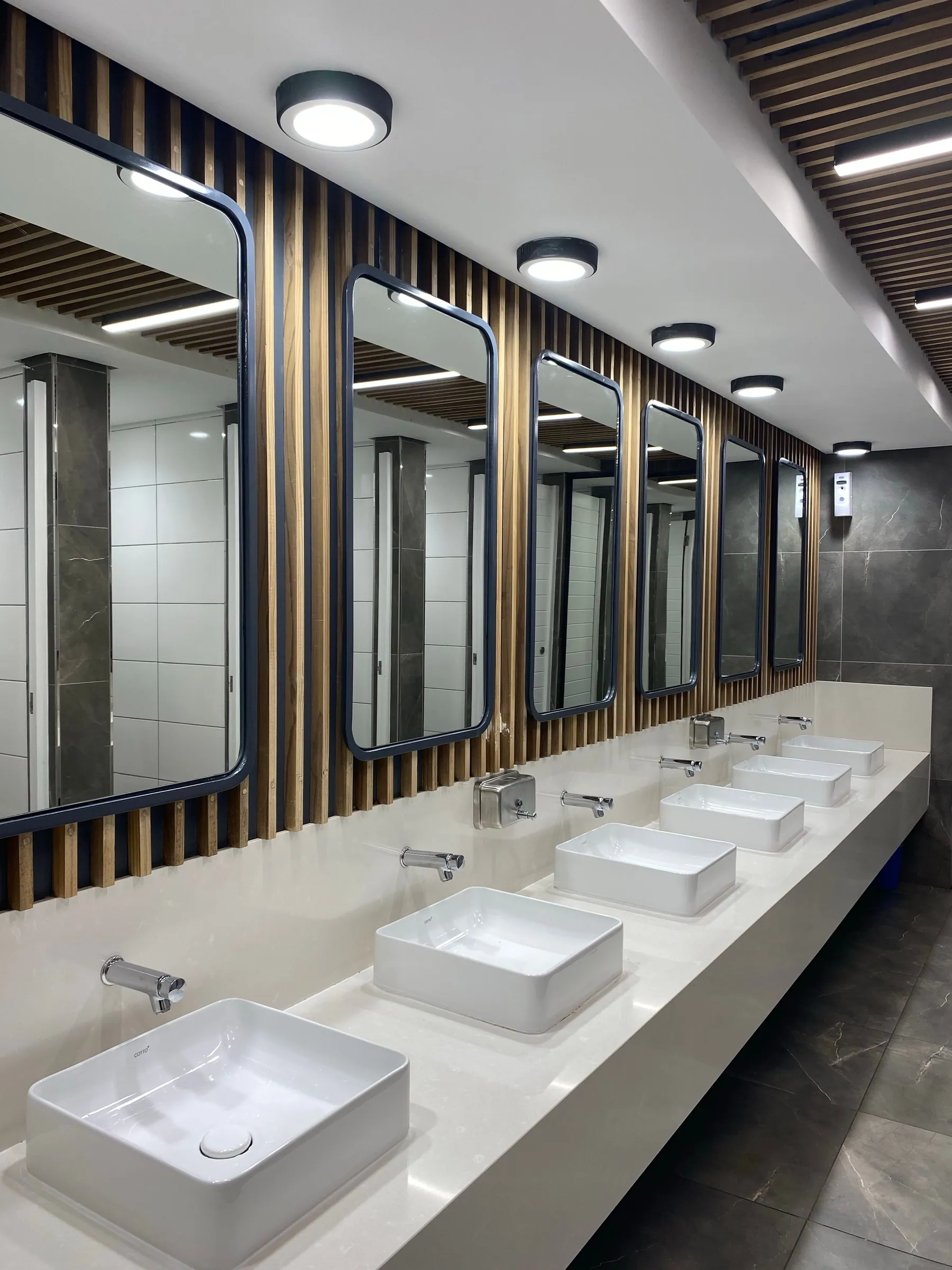 Commercial restroom with a row of vessel sinks and mirrors