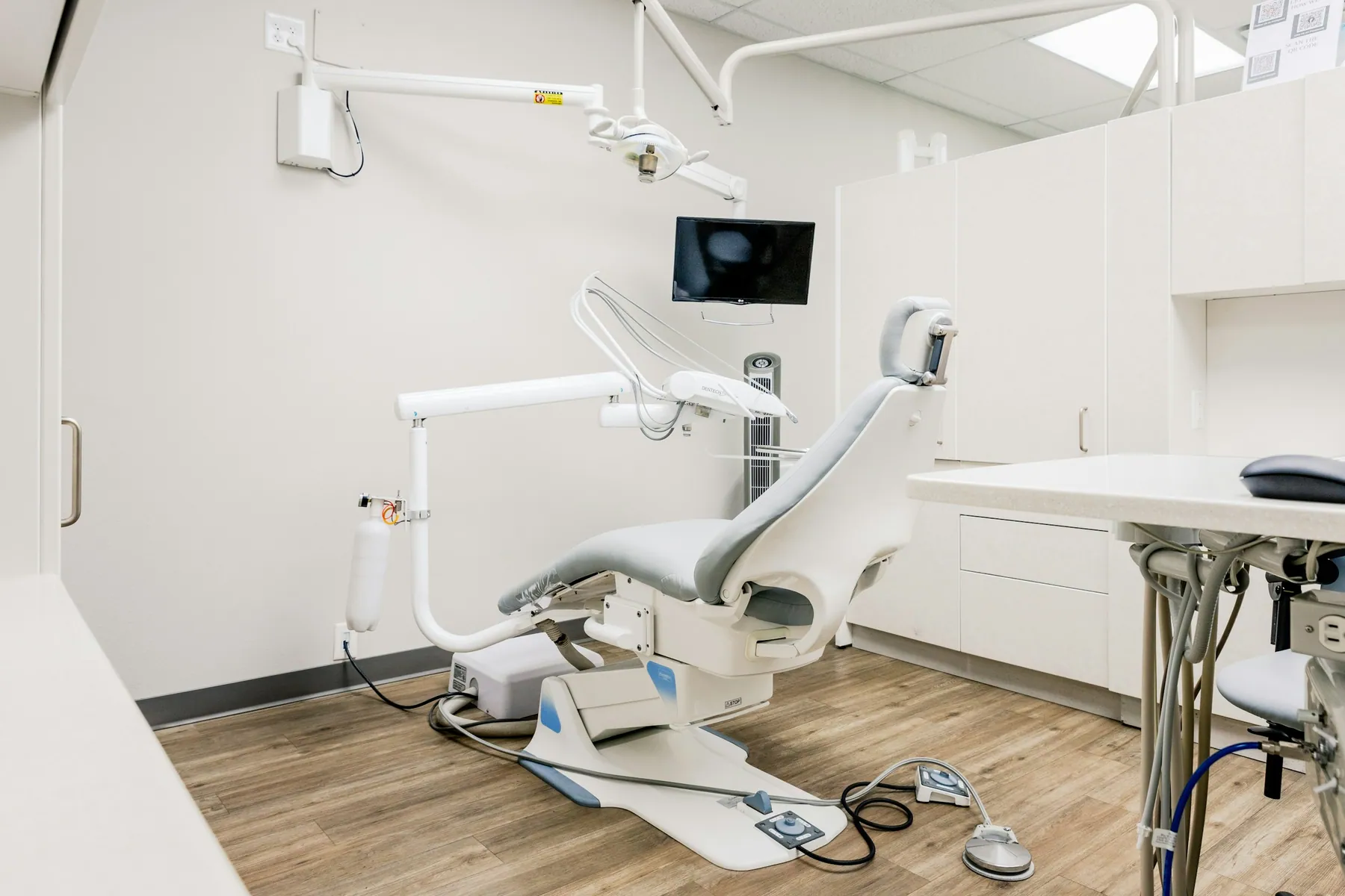 Modern dental operatory with a patient chair and wood floor