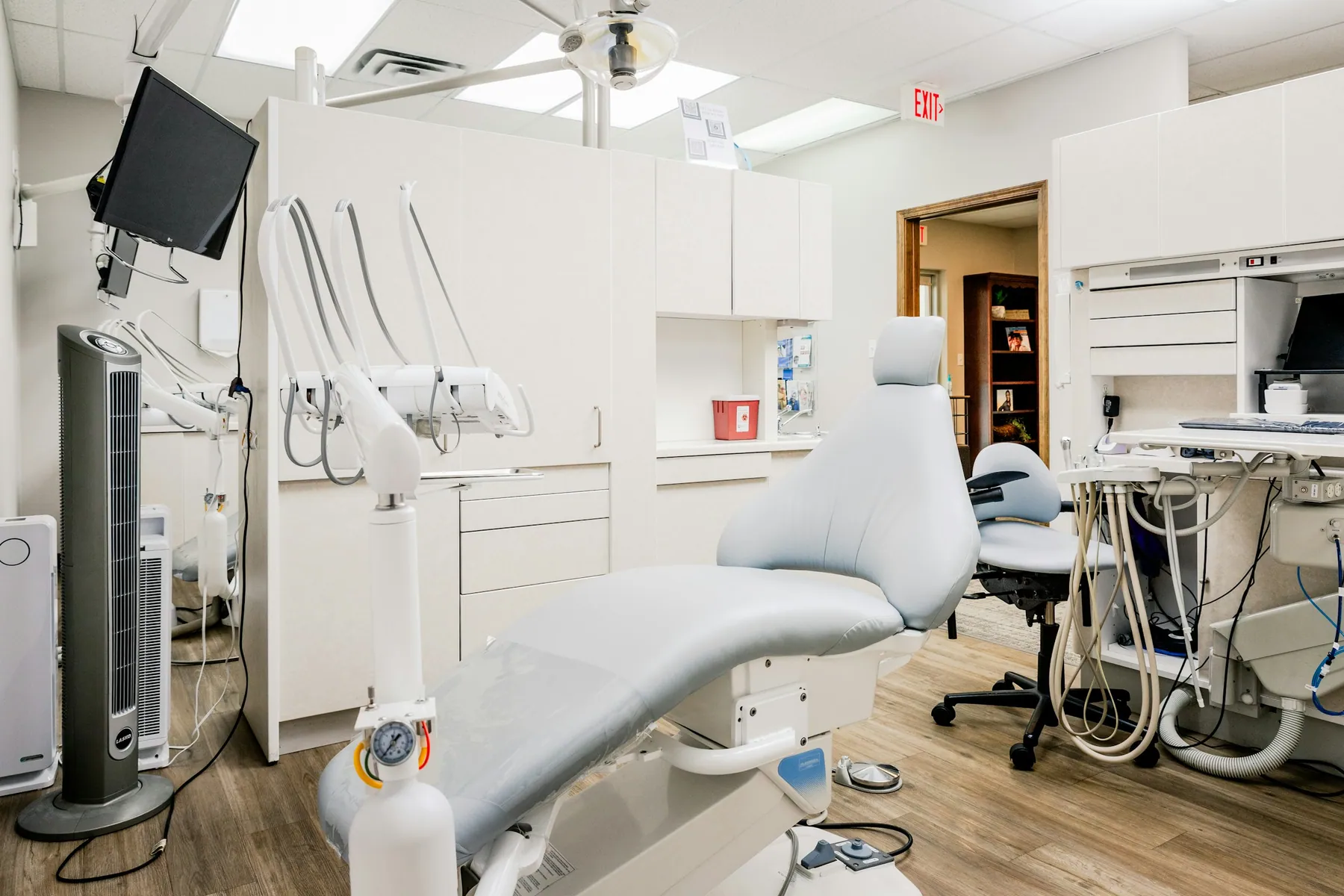 Dental exam room with a light-blue patient chair