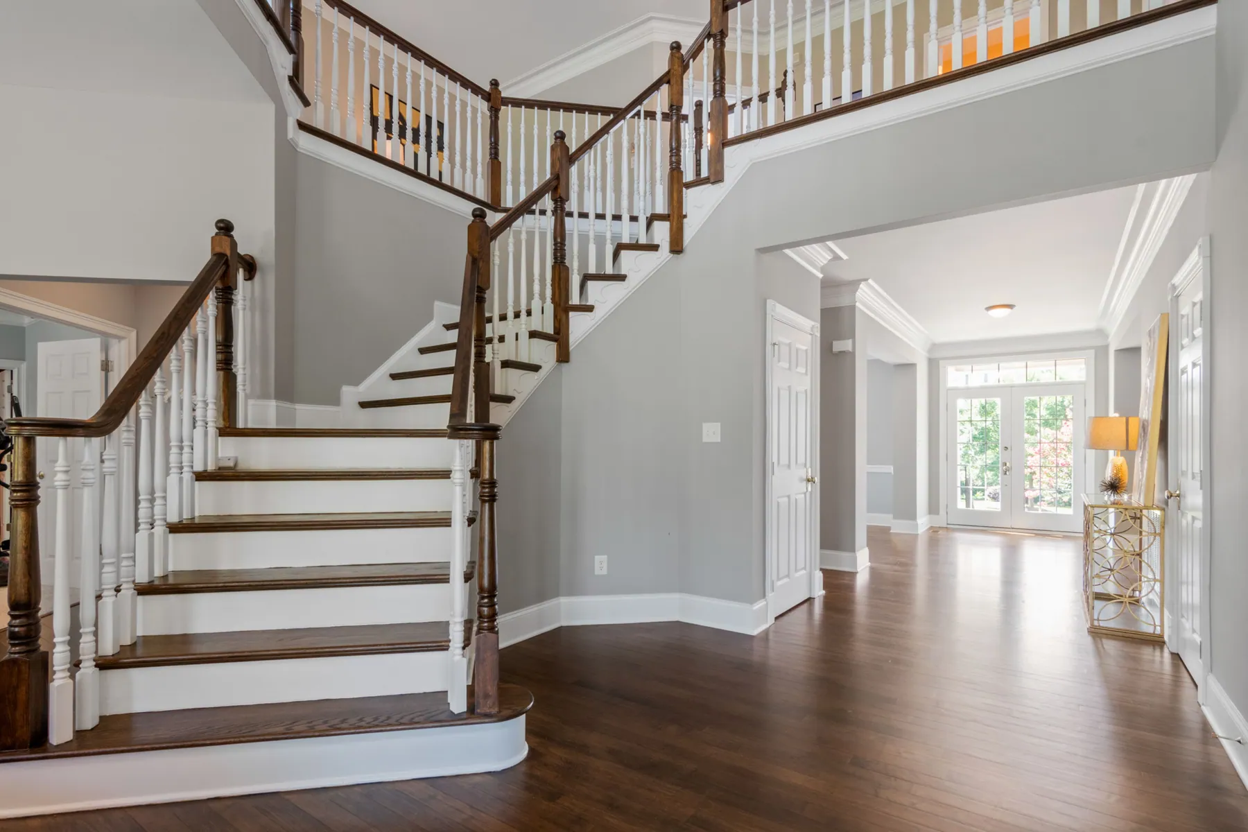 Two-story foyer with a curved staircase and hardwood floors