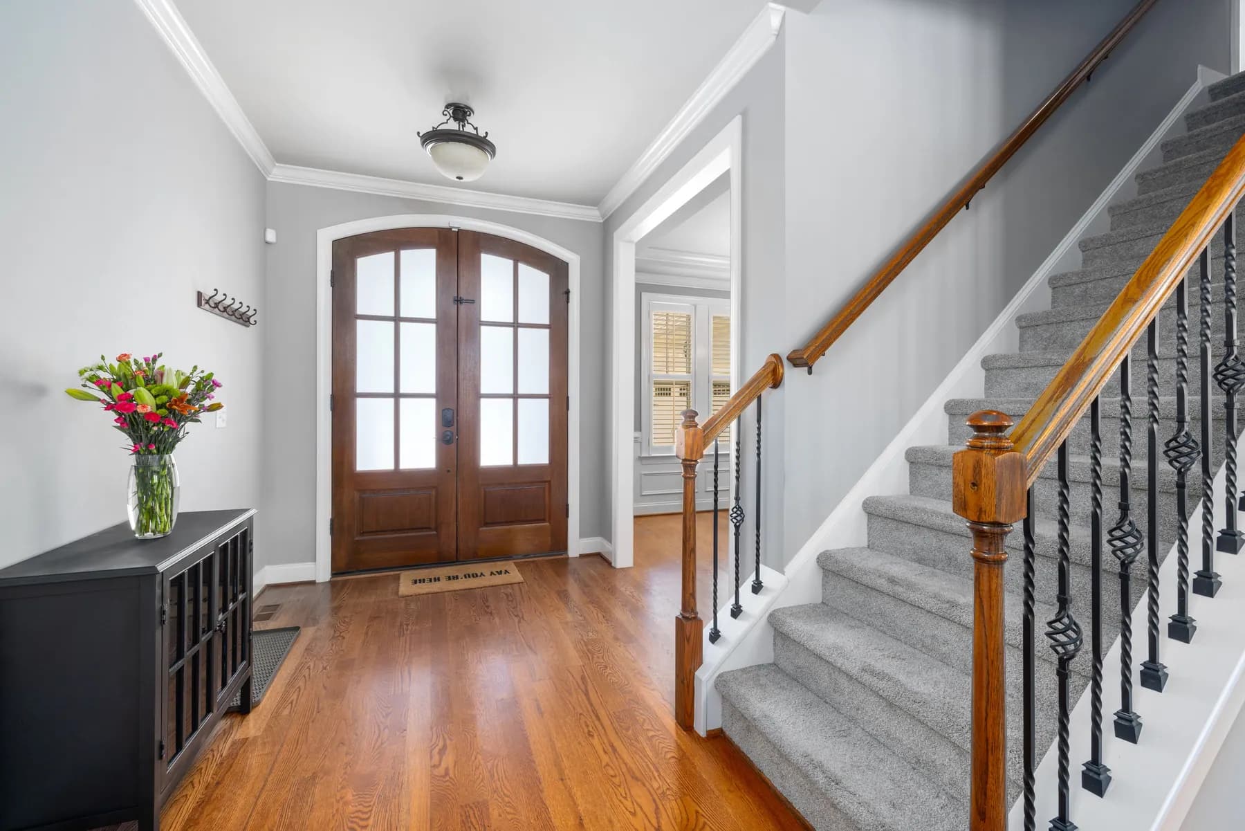 Front entry with double doors, carpeted stairs and iron balusters