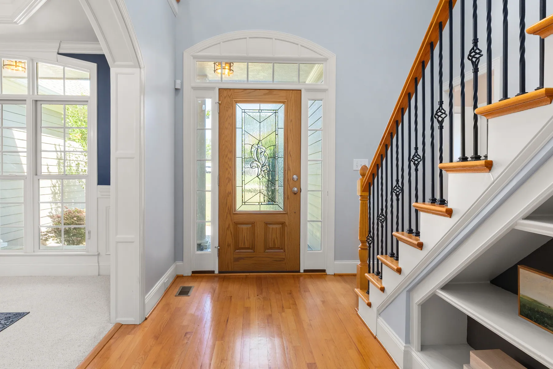 Bright entry with a leaded-glass front door and open staircase