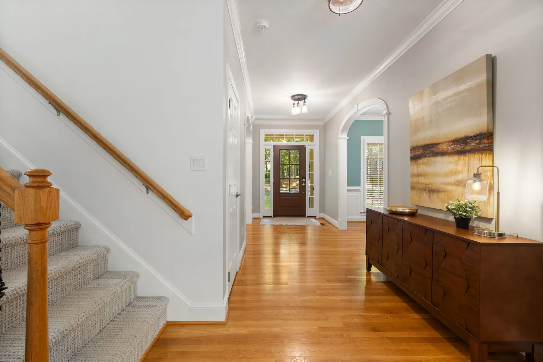 Hardwood entry hall with a staircase and console table