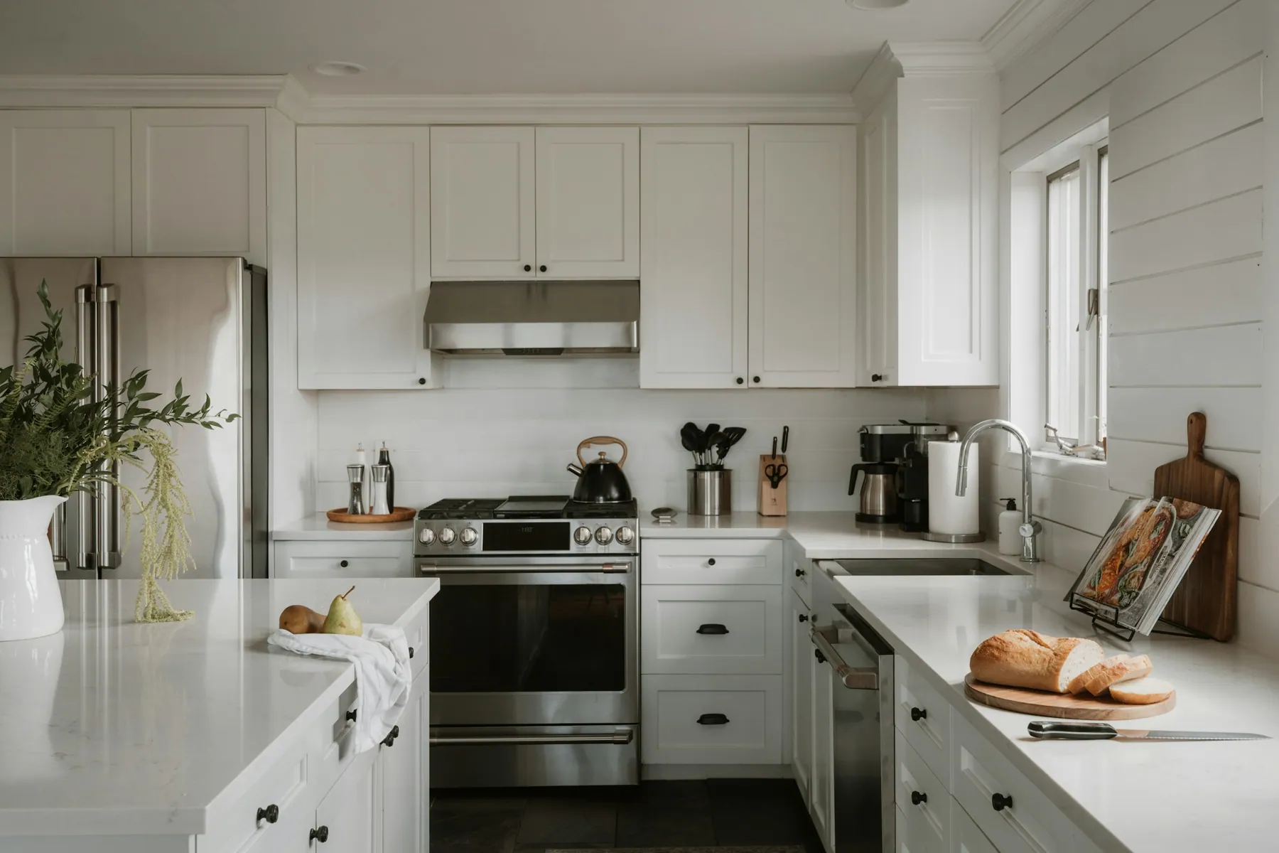 Bright white shaker kitchen with a stainless range and tidy counters