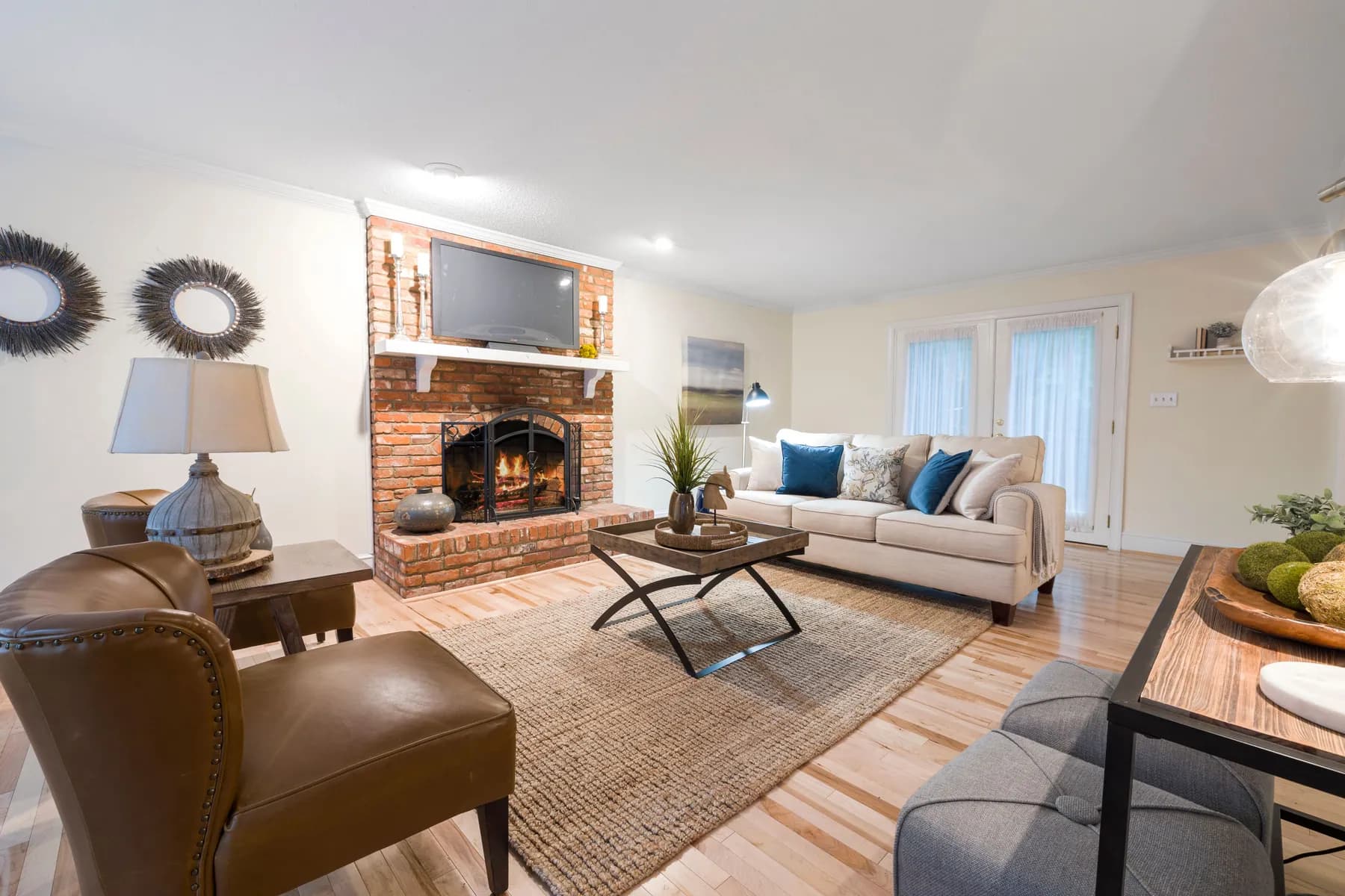Family room with a brick fireplace, a neutral sofa and hardwood floor