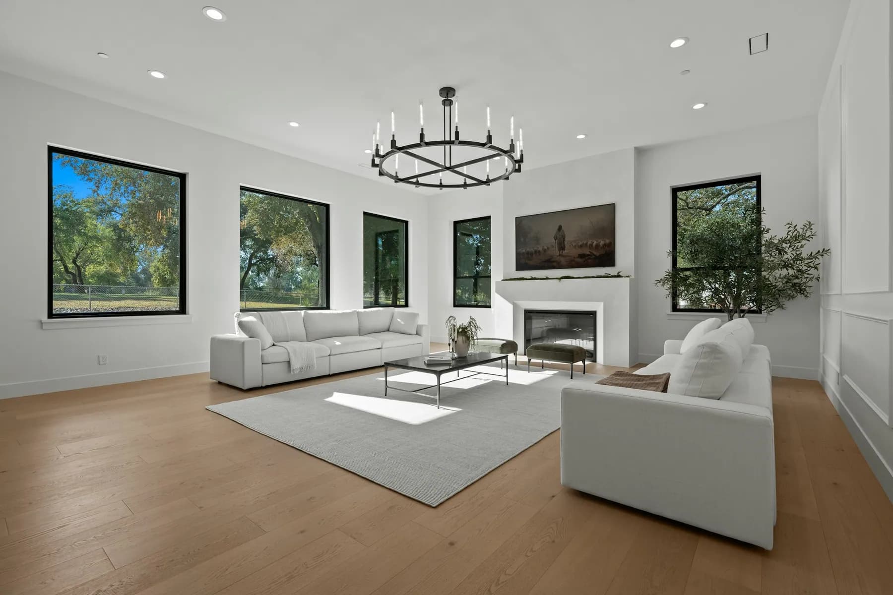 Spacious living room with white sofas, a fireplace and black-frame windows