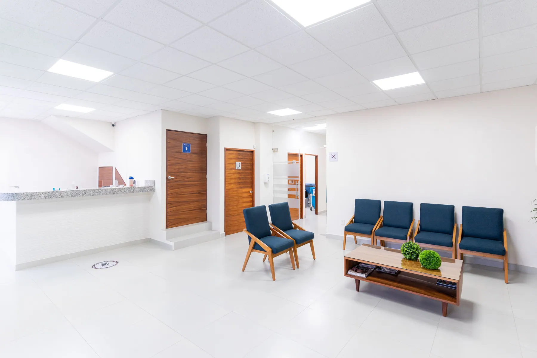 Bright medical waiting room with a reception counter and chairs