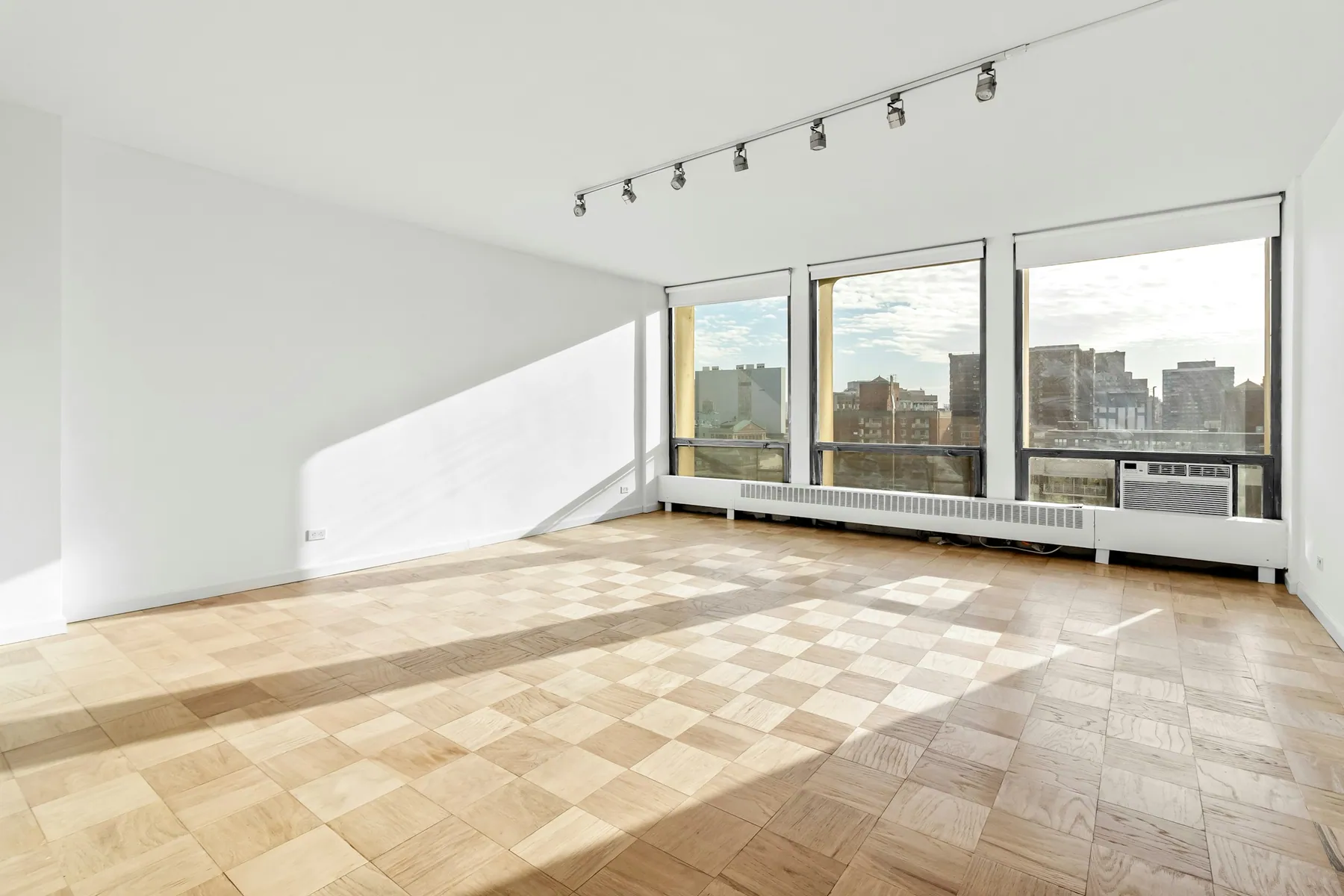 Empty sunlit apartment with a parquet floor