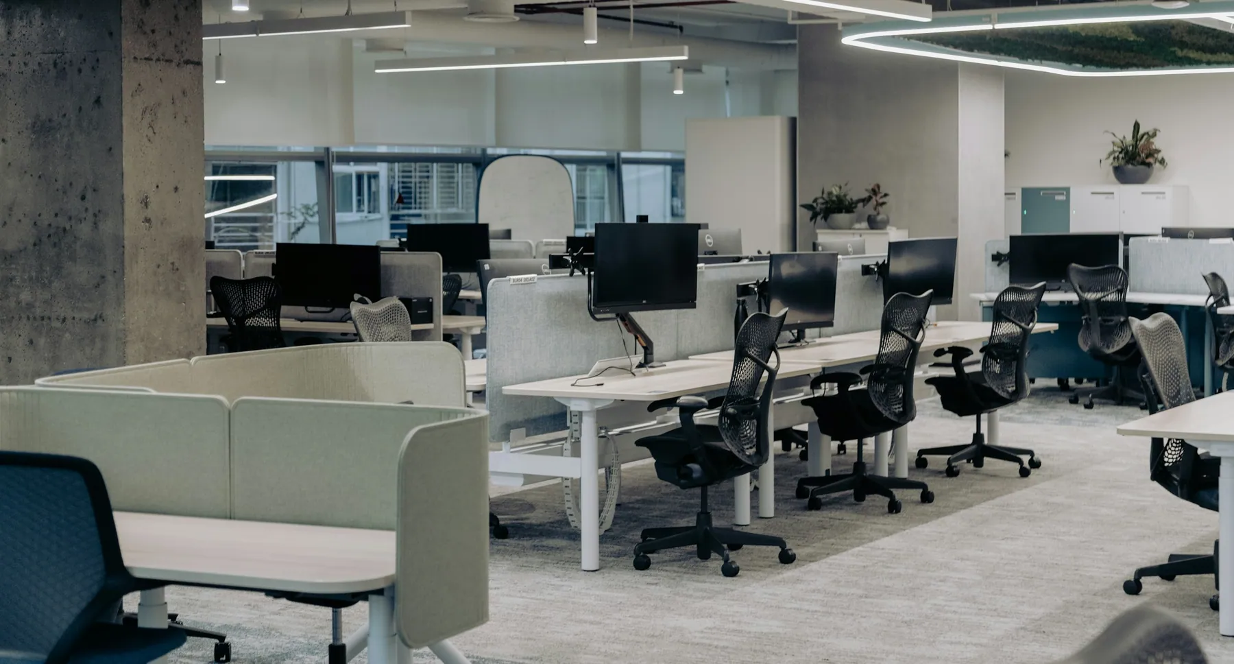 Open-plan office with rows of desks and task chairs