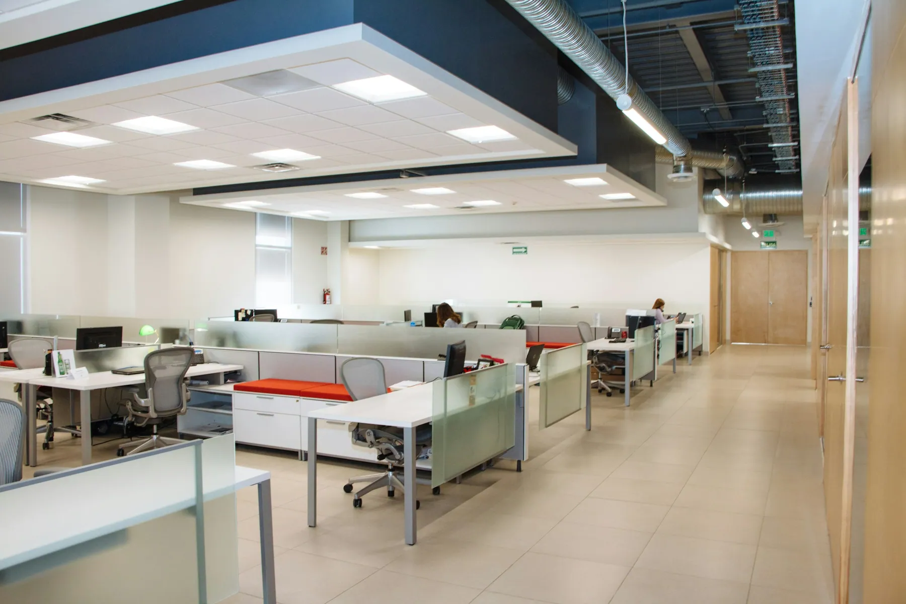 Large open office with cubicles and a drop ceiling