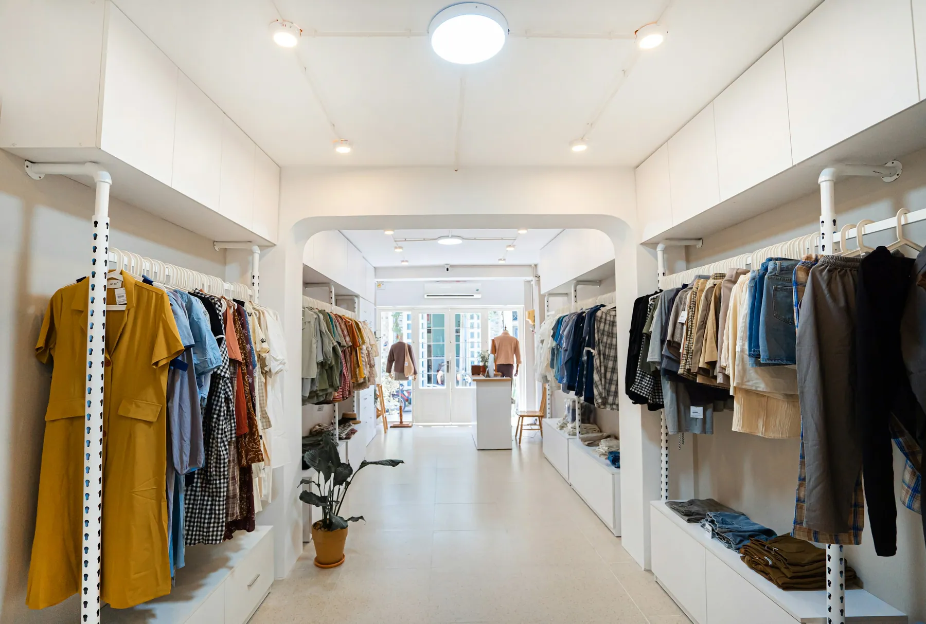 Bright clothing boutique with white racks and a terrazzo floor