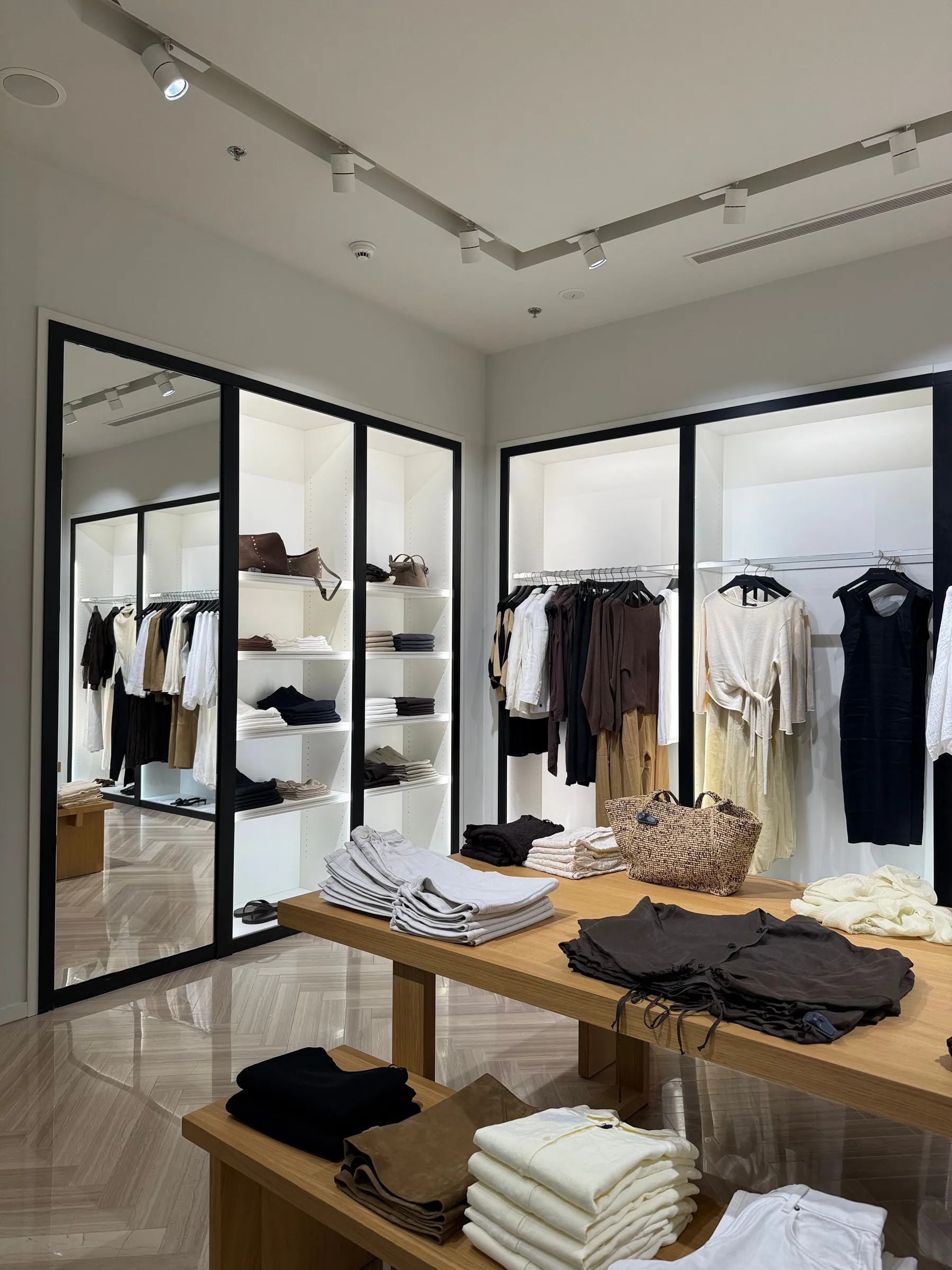 Minimal apparel store with a display table and mirrored walls