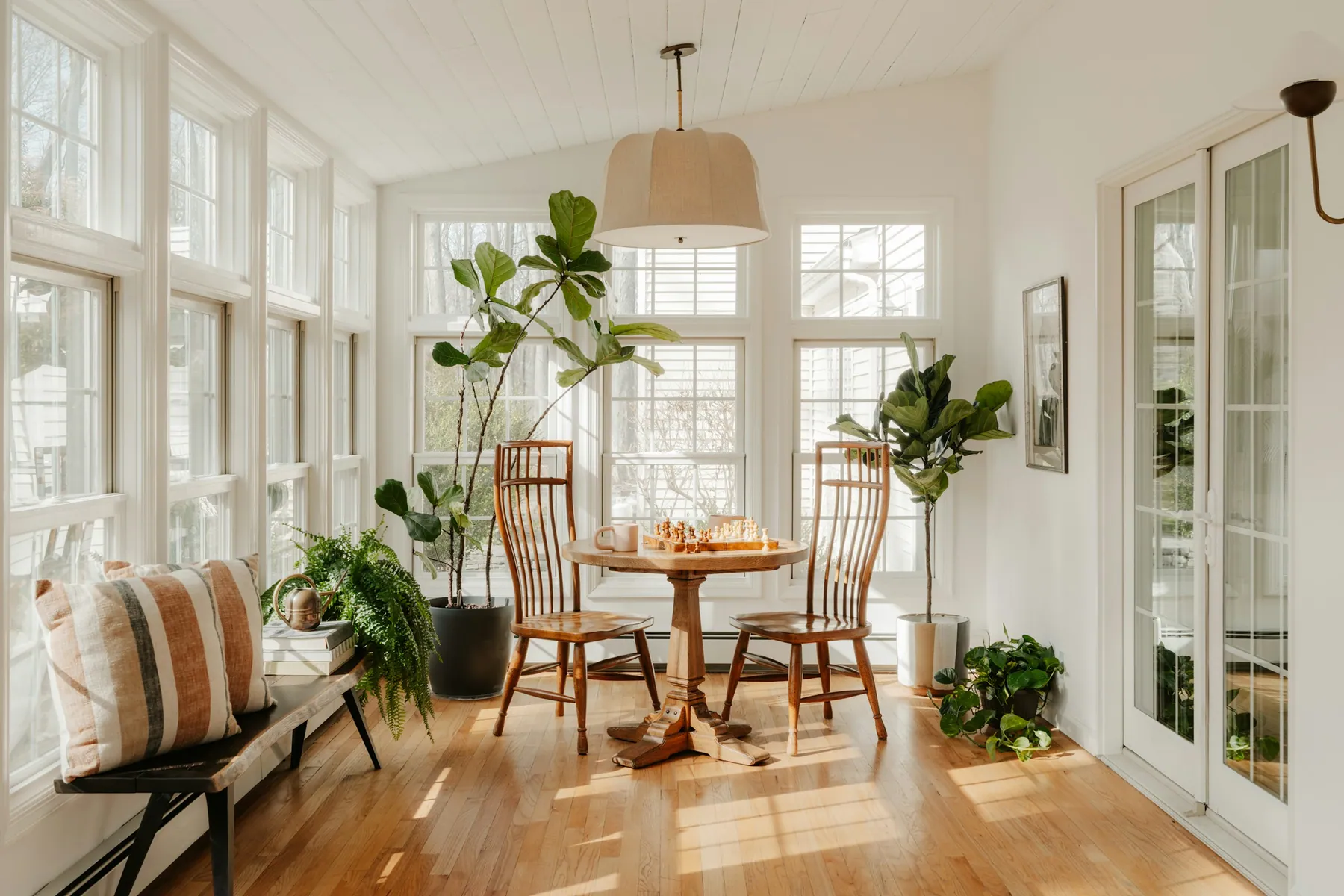 Sunroom with walls of white-framed windows